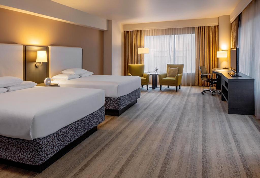 シアトルにあるハイアット アット オリーブ 8のベッド2台とデスクが備わるホテルルームです。