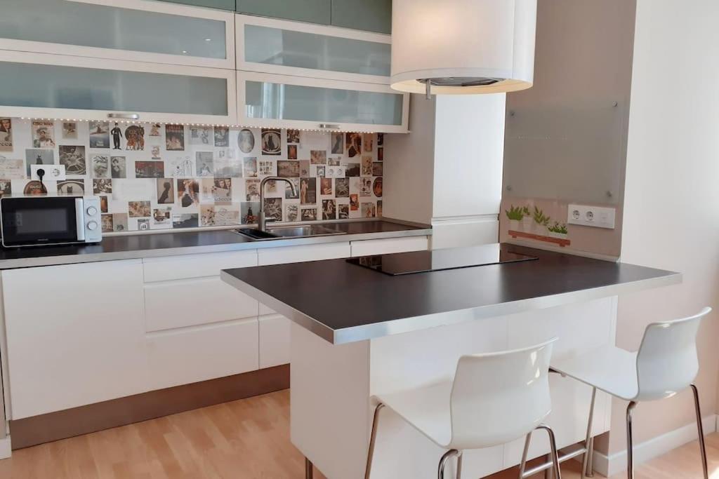 加的斯的住宿－Mar y Sol，厨房配有白色橱柜和黑色台面