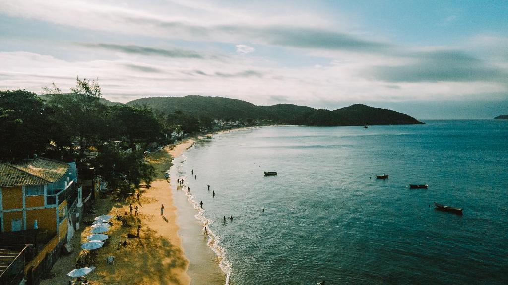 - une vue sur la plage avec des gens dans l'eau dans l'établissement Selina Buzios, à Búzios