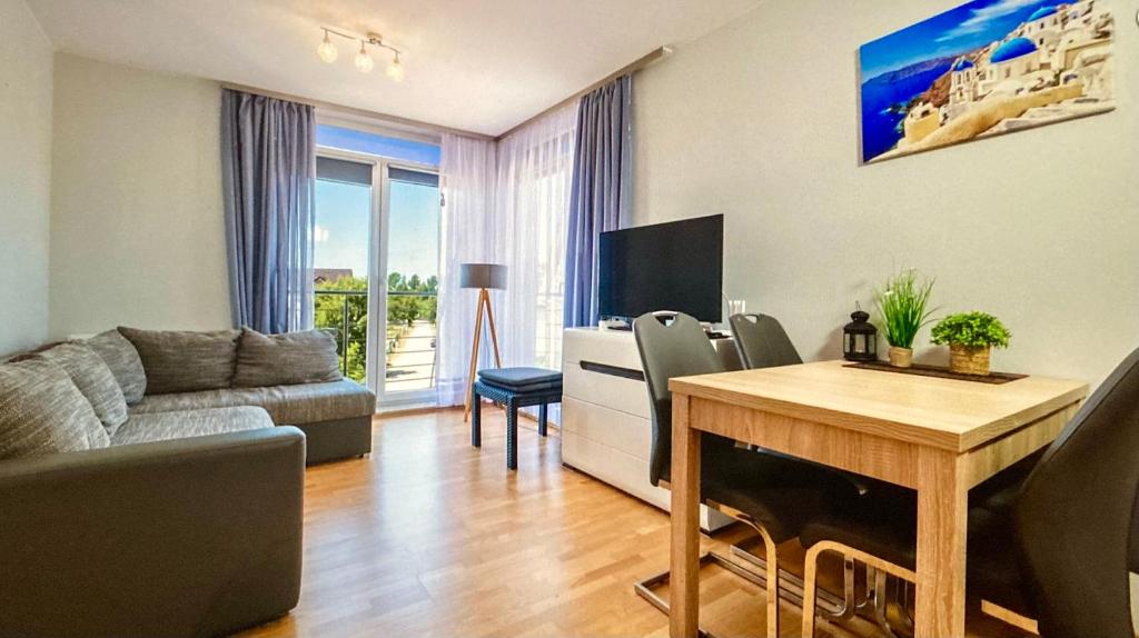 a living room with a table and a couch at Apartament Atlantycki in Jastrzębia Góra