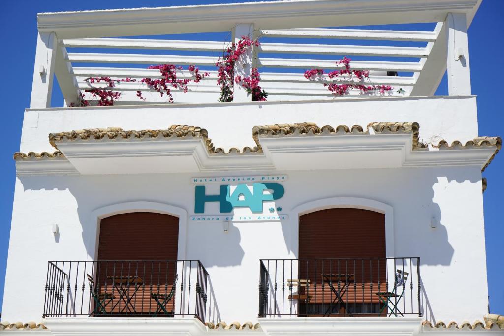 un bâtiment blanc avec un panneau sur lequel figure la pancarte dans l'établissement Hotel Avenida Playa, à Zahara de los Atunes