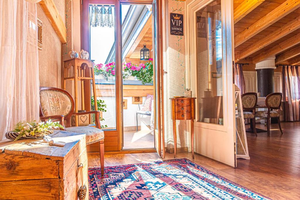 een woonkamer met een open deur naar een balkon bij B&B Alla Loggia dell'Imperatore in Levico Terme