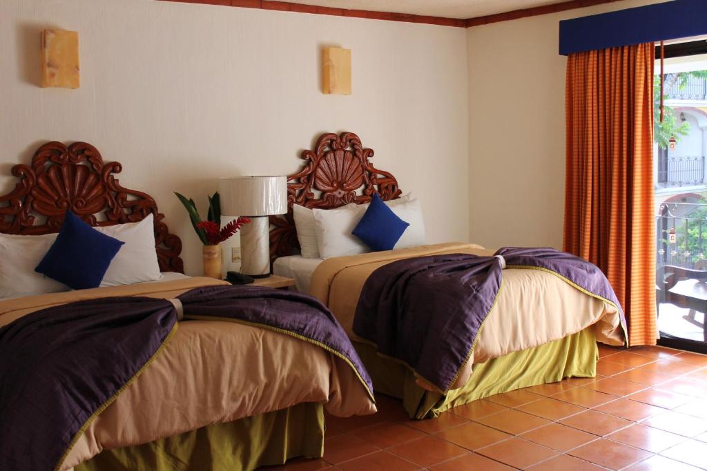 a bedroom with two beds and a window at Ecotel Quinta Regia in Valladolid