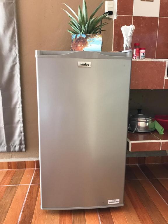 einen Kühlschrank auf dem Boden mit einer Ananas darüber in der Unterkunft Estudios Rehilete in Holbox