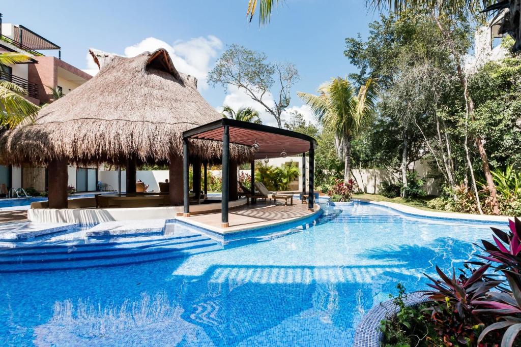 a pool at a resort with a pavilion at Paramar Terra in Tulum