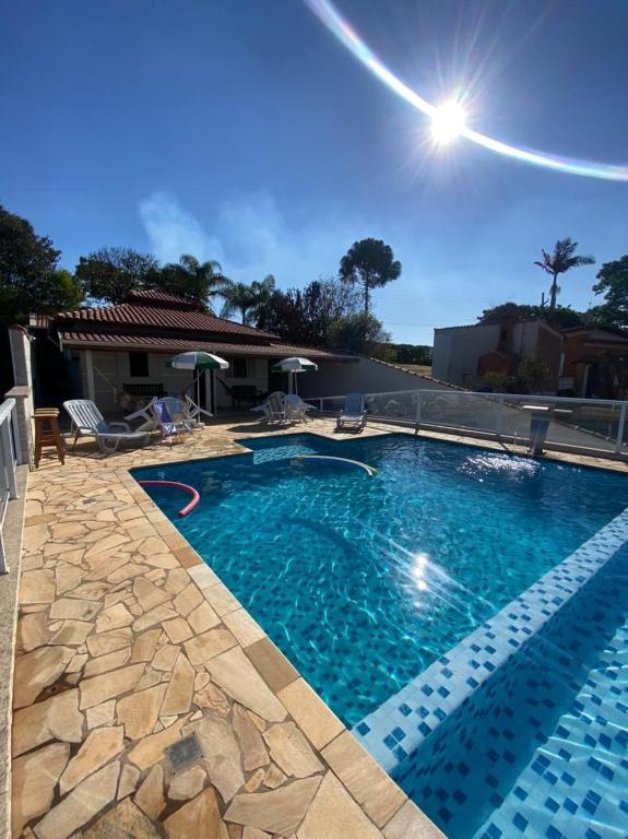 a large swimming pool with blue water in a yard at RANCHO KWILL in Serra Negra
