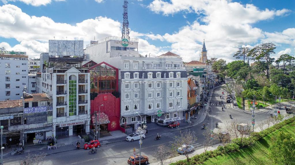 a large white building on a street in a city at Khách sạn Park Hotel Dalat in Da Lat