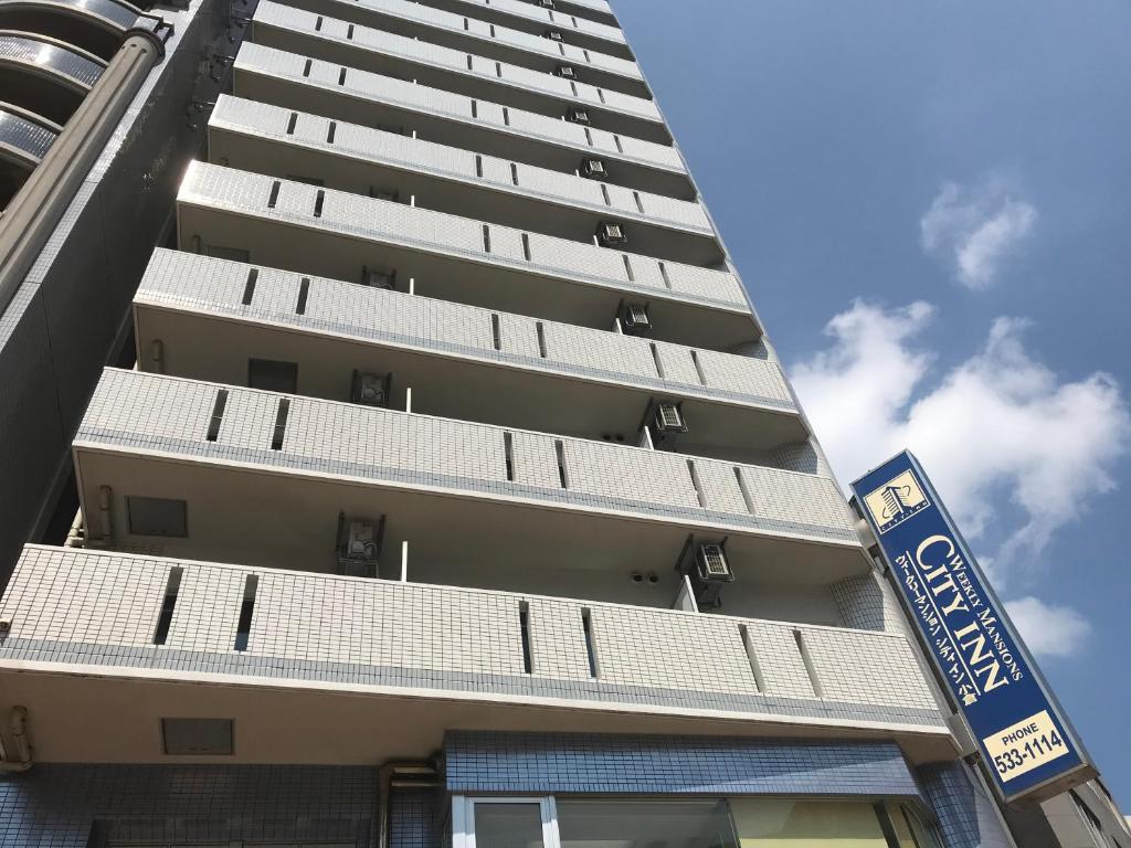 北九州市にあるウィークリー ＆ マンスリー シティ イン 小倉の前に看板がある高い建物