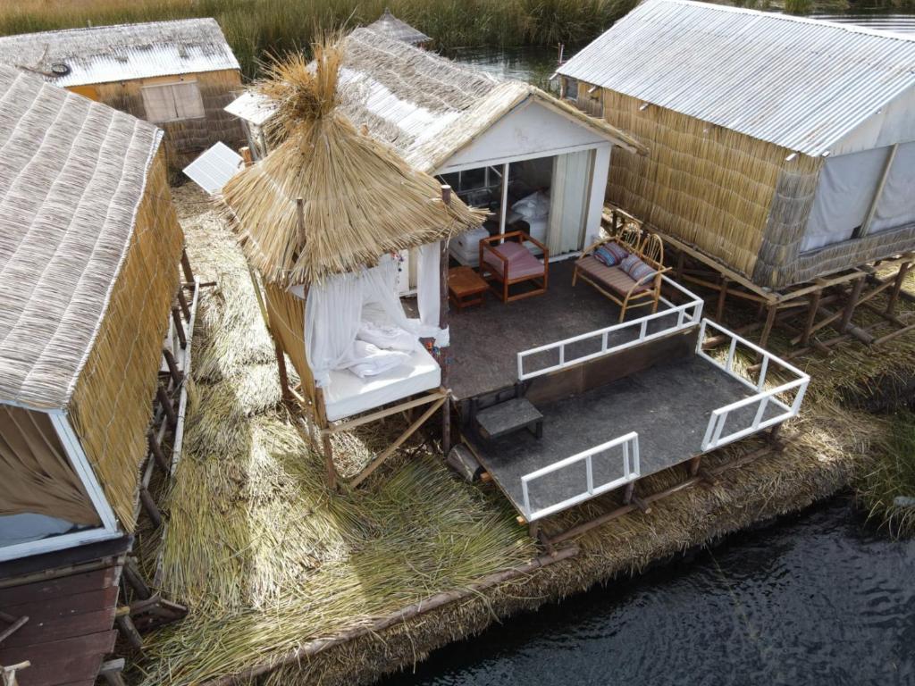 an aerial view of a group of huts on the water at Uros Tikarani hotel in Puno