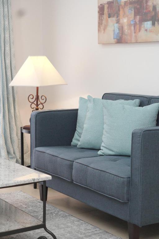 a blue couch in a living room with a lamp at Sta Barbara Residence Hotel in Cebu City