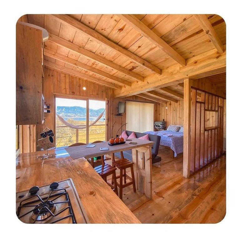 eine Küche und ein Wohnzimmer mit einem Tisch in einer Hütte in der Unterkunft Villa De Los Sueños in Pasto