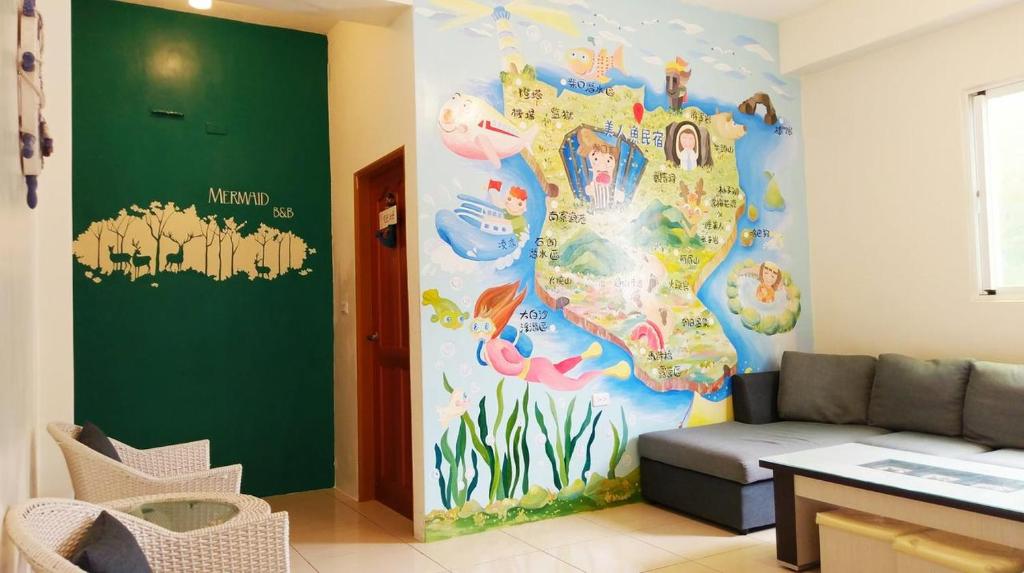 un soggiorno con un murale di sirena sul muro di Mermaid B&B a Green Island