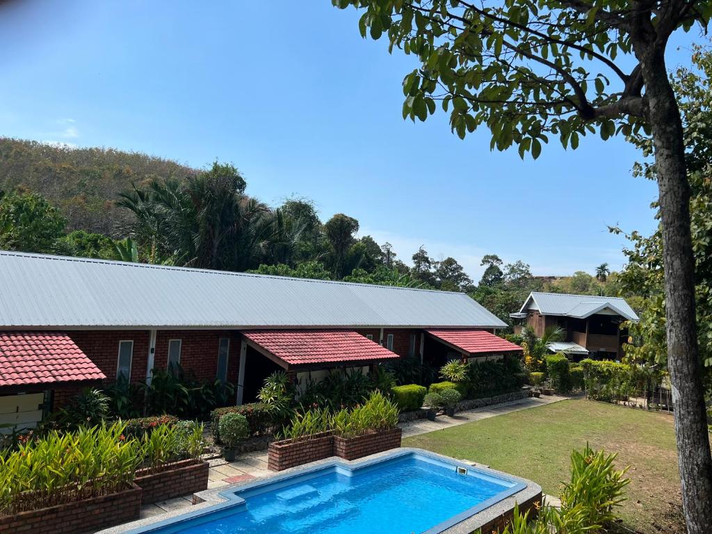 a house with a swimming pool in front of it at Hujung Kampung Estate in Pantai Cenang