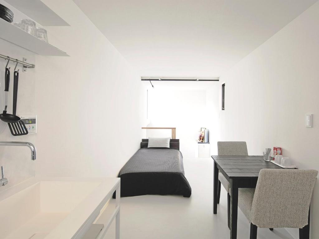 a bedroom with a bed and a table and chairs at Oku-Shibu Residence in Tokyo