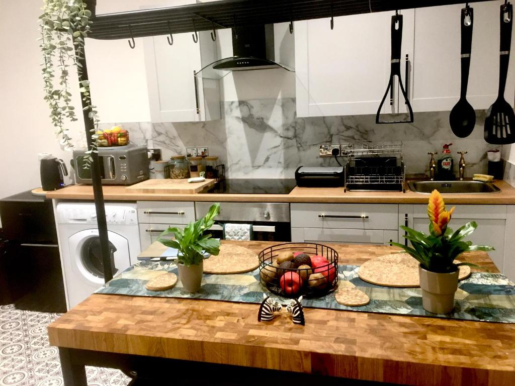 a kitchen with a table with a bowl of fruit on it at Cozy and modern flat in the heart of Hawick in Hawick