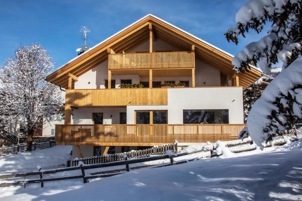 une maison dans la neige avec un balcon dans l'établissement Editlodge "Dessura", à Badia