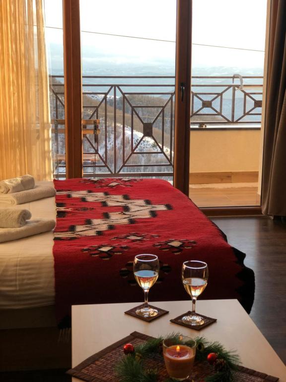a room with a bed and two glasses of wine at Milmari M12 in Kopaonik