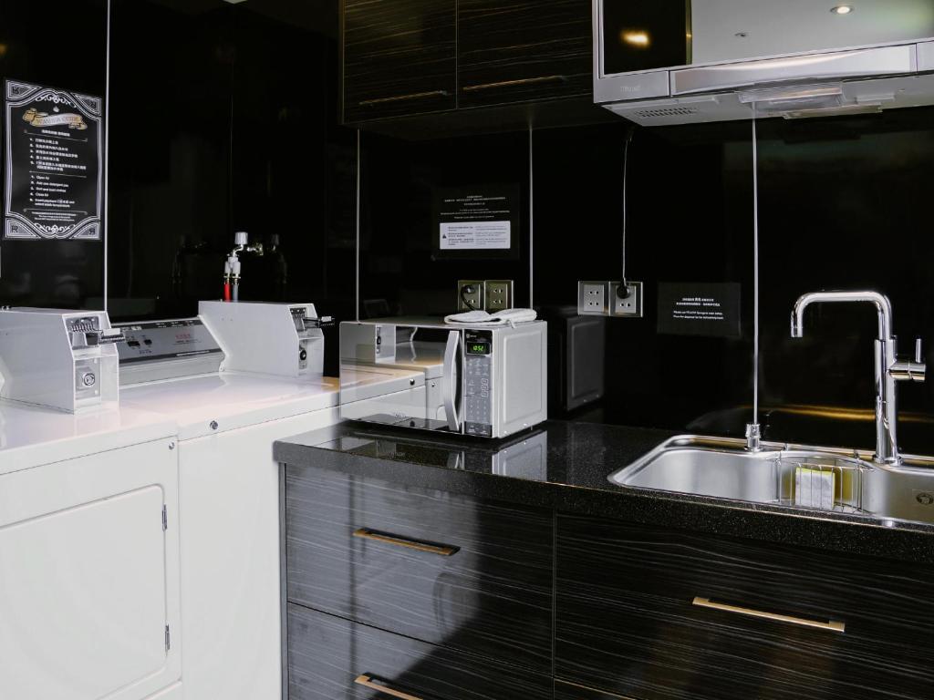 a kitchen with white appliances and a sink at Hotel Relax I in Taipei