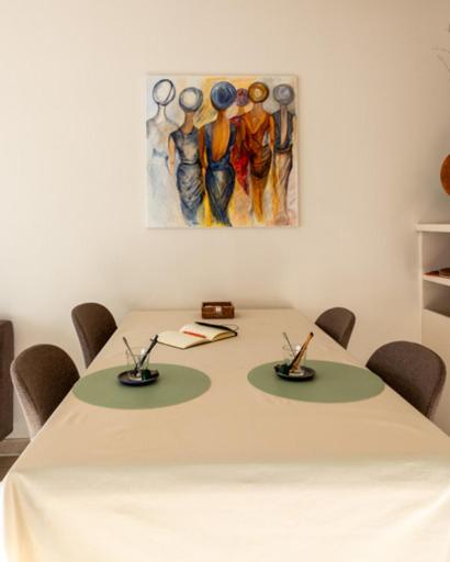 a white table with chairs and a painting on the wall at Apartment Casino in Nieuwpoort
