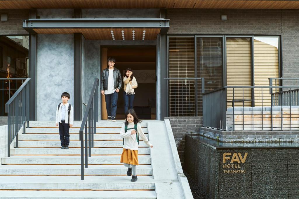 duas crianças a subir as escadas de um edifício em FAV HOTEL TAKAMATSU em Takamatsu