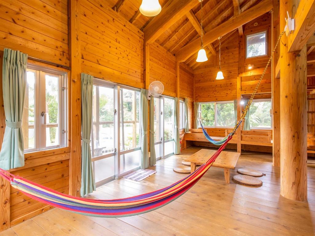 a room with a hammock in a log cabin at Irunty Futademura in Iriomote
