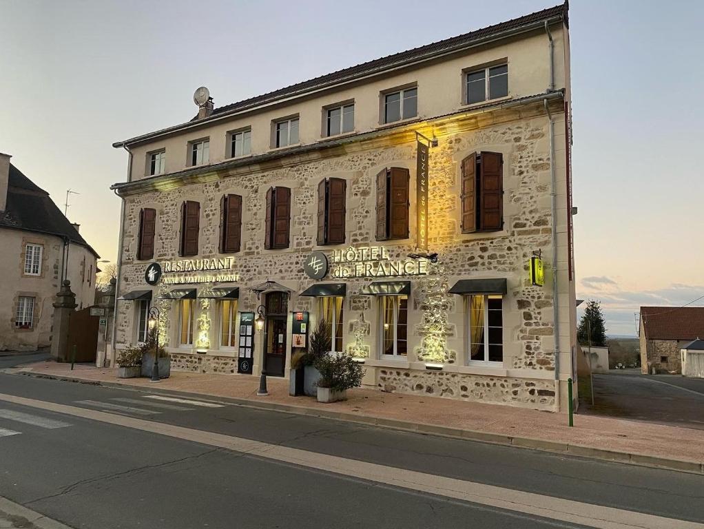 un antiguo edificio de piedra en una calle de la ciudad en Hôtel de France, en Montmarault