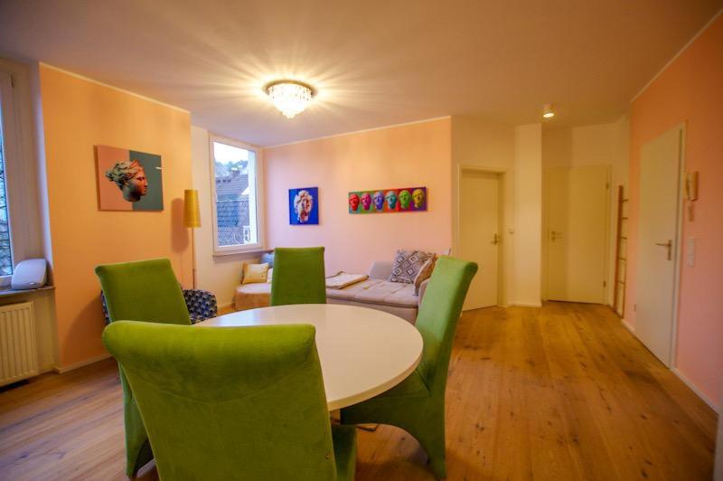 シュヴェルムにあるServiced Apartement Xanthurusのリビングルーム(テーブル、緑の椅子付)