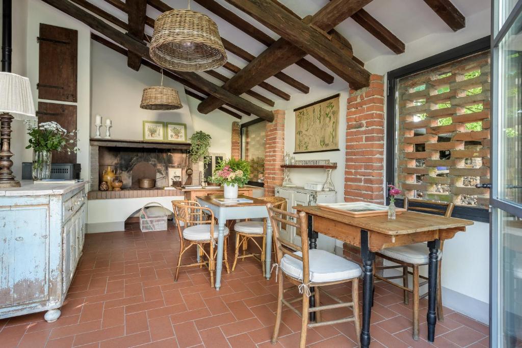 All'Ombra Del Tiglio في بستويا: مطبخ مع طاولة وكراسي ومدفأة