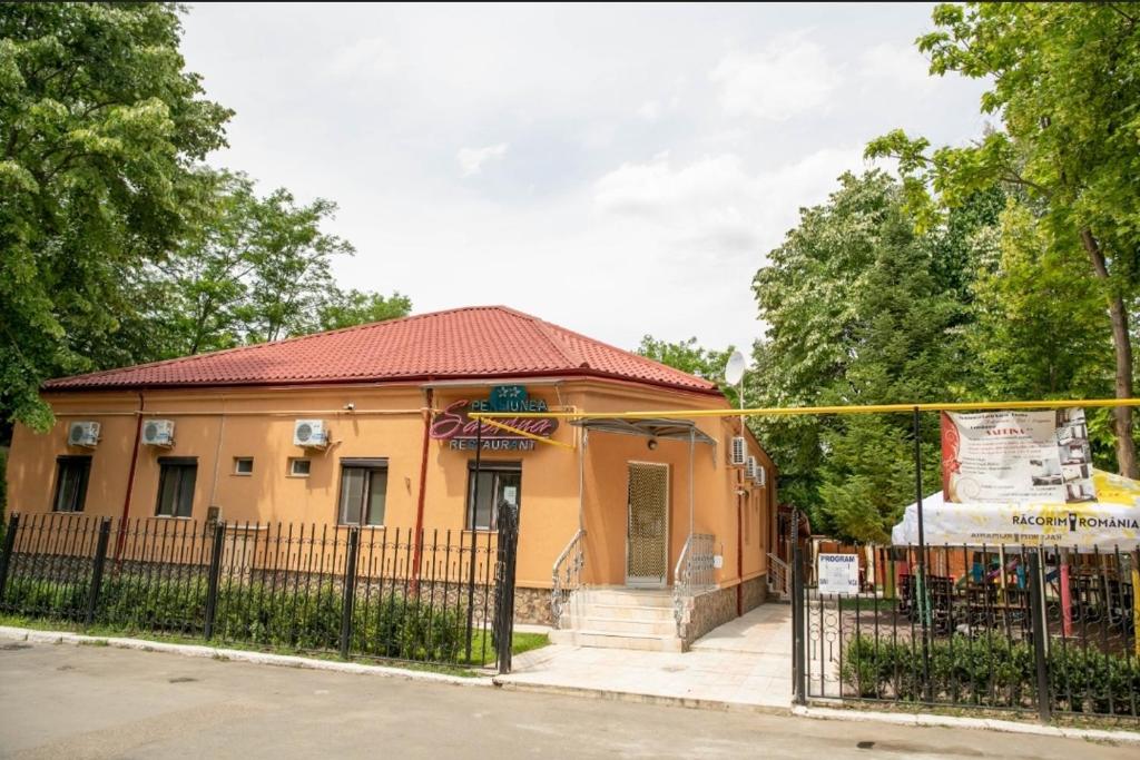 a building with a fence in front of it at Pensiunea Sabrina in Lacu Sărat