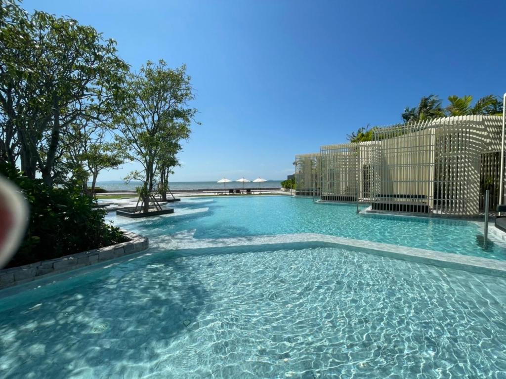 basen z niebieską wodą przed oceanem w obiekcie Residence By Hello Pattaya At Veranda w mieście Jomtien Beach