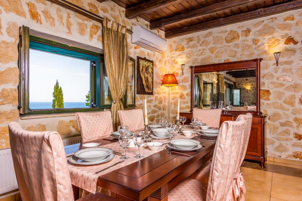 a dining room with a wooden table and chairs at Xigia Escape villas in Khartáta