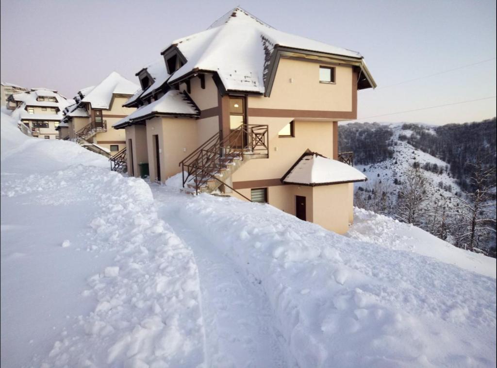 a pile of snow in front of a building at Apartmani Krstojević Kopaonik in Kopaonik