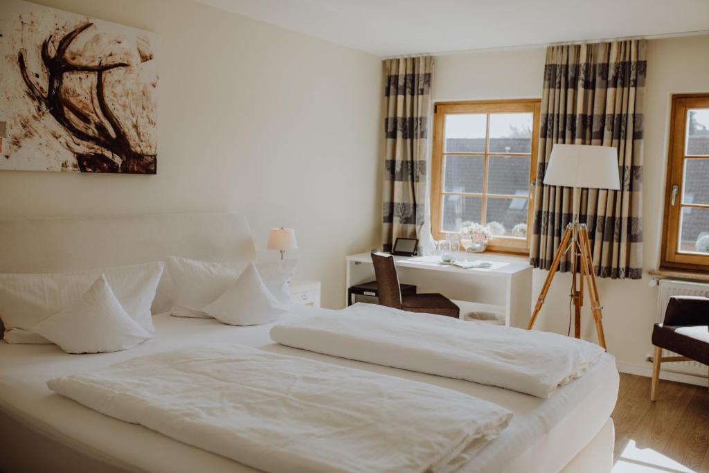 Habitación blanca con cama, escritorio y ventana en Hotel Havelser Hof, en Garbsen