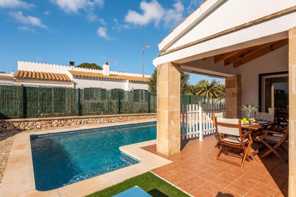 eine Villa mit einem Pool und einem Haus in der Unterkunft Villa Ses 5 Claus in Cala en Blanes