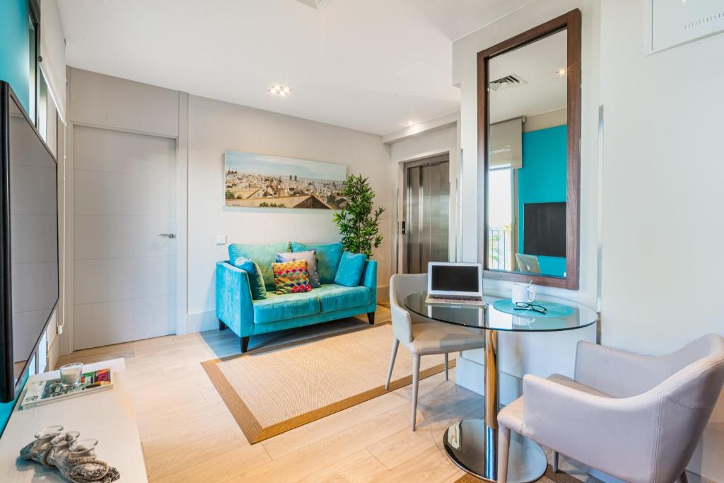 a living room with a blue couch and a glass table at Kronos on the Beach suite 3 in Barcelona