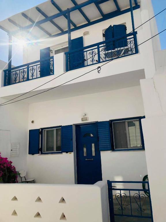 a white building with a blue door and a balcony at fanis sweet home in Kampos Paros
