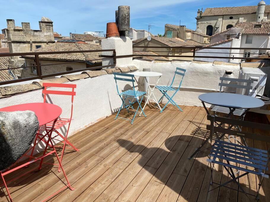 una terrazza con sedie e tavoli sul tetto di La tour 2: Appart neuf au cœur de la petite venise a LʼIsle-sur-la-Sorgue