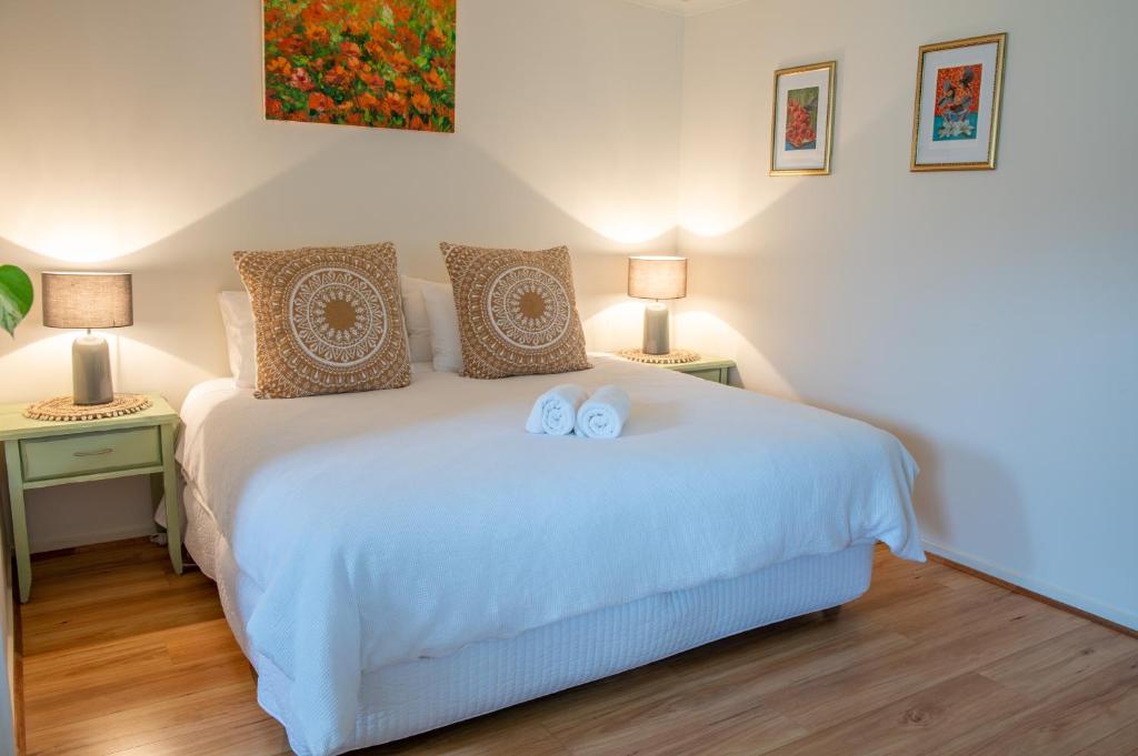 a bedroom with a white bed with two towels on it at Bower On Becket - Couples Retreat in Rye