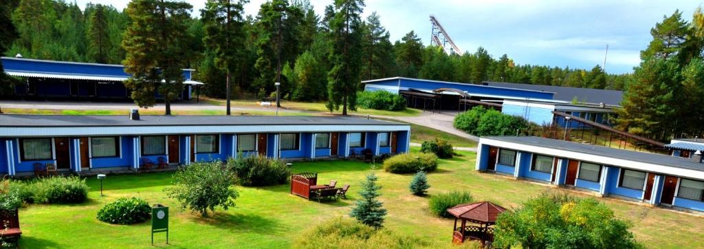 un gran edificio azul con un patio delante en Hotelli Hiittenharju, en Harjavalta