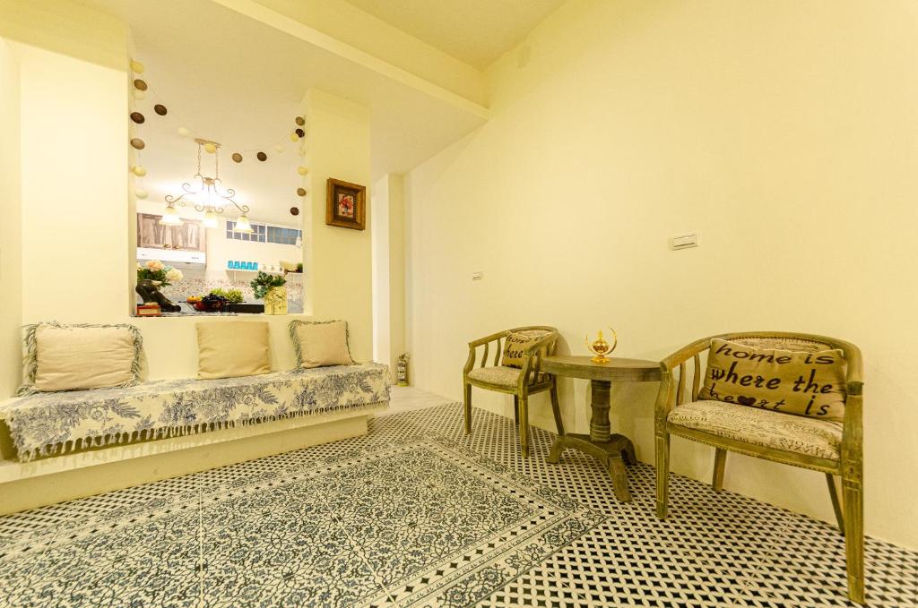 ein Zimmer mit einem Sofa, 2 Stühlen und einem Tisch in der Unterkunft 歐羽包棟 in Puli