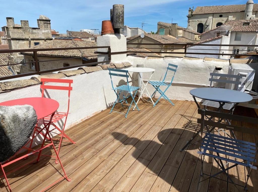 una terraza con sillas y mesas en el techo en La tour 3: Appart au cœur de la petite Venise en LʼIsle-sur-la-Sorgue