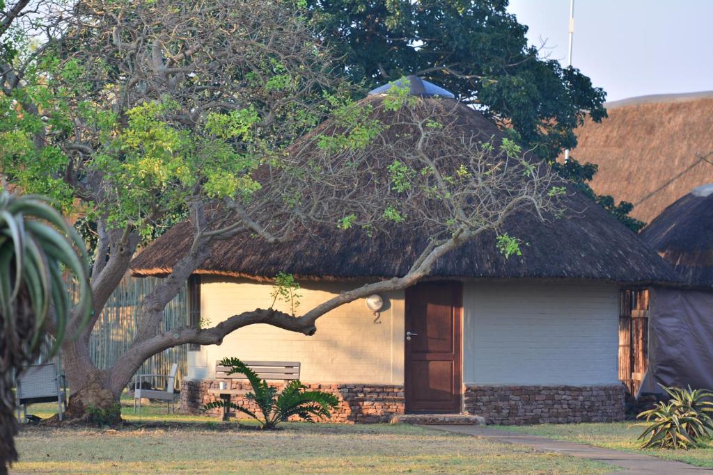 a small house with a thatch roof at Bayala Private Safari Lodges in Hluhluwe