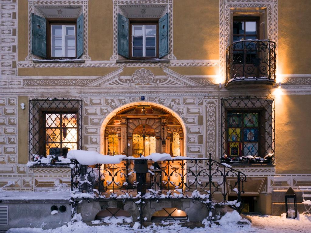 a building with a door in the snow at Historic Hotel Chesa Salis in Bever