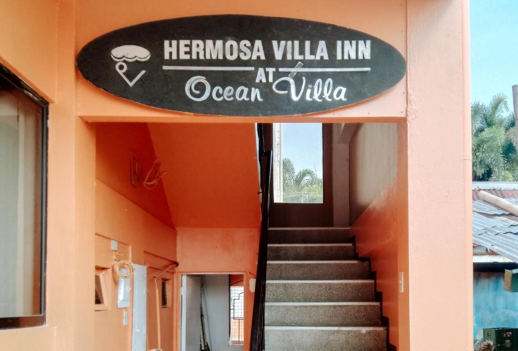 a sign on the side of a building with a staircase at Ocean Villa in Iloilo City