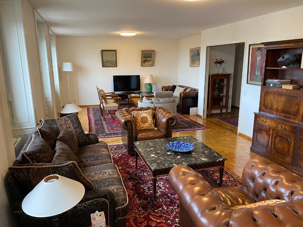 a living room with leather couches and a table at Genève, plein centre,belle vue Lac, splendide et grand appartement in Geneva