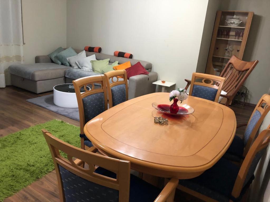 a wooden table and chairs in a living room at Kris's apartment in Lezhë