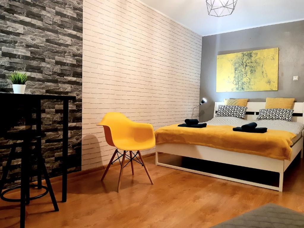 sypialnia z łóżkiem i żółtym krzesłem w obiekcie Apartament blisko morza - Yellow Stone w Gdańsku