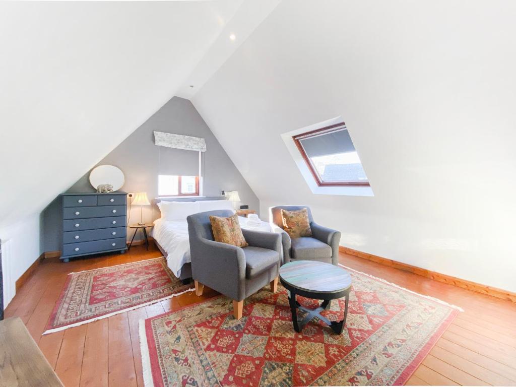 a bedroom with a bed and a chair and a table at Little Dene Lodge in Pakenham