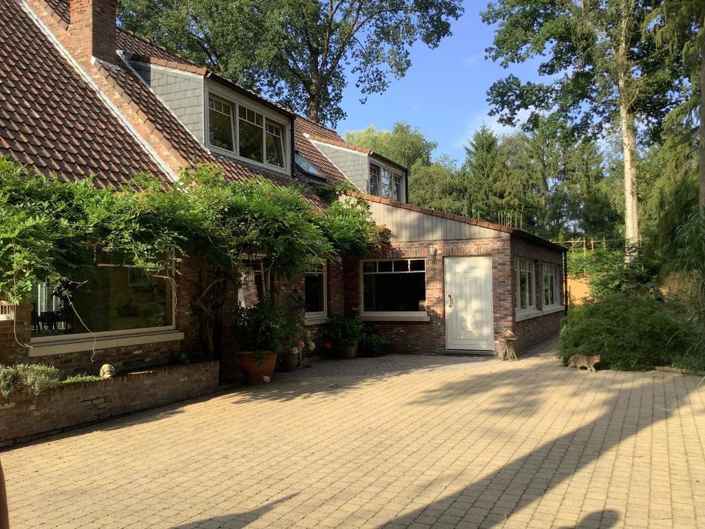 a brick house with a garage and a driveway at 't Greefsch Geluck in Kalmthout