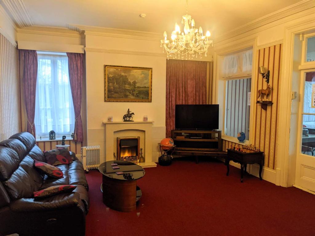 a living room with a couch and a fireplace at Altavia Hotel in Sandown